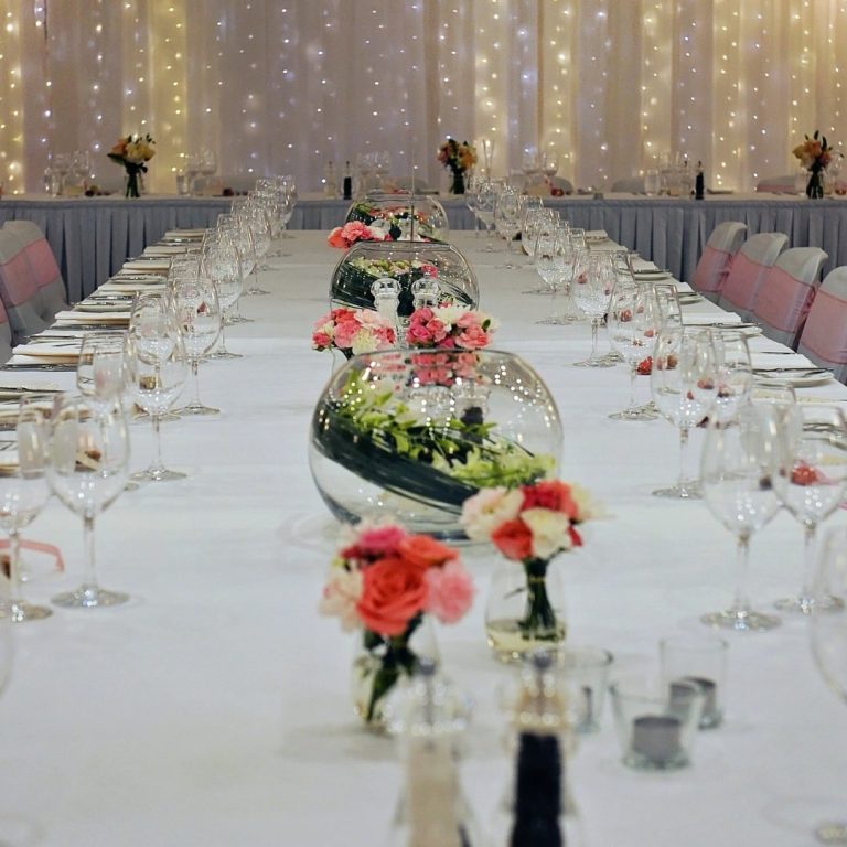 Gedeckter Tisch bei einer Hochzeit mit Blumen Gläsern und Besteck