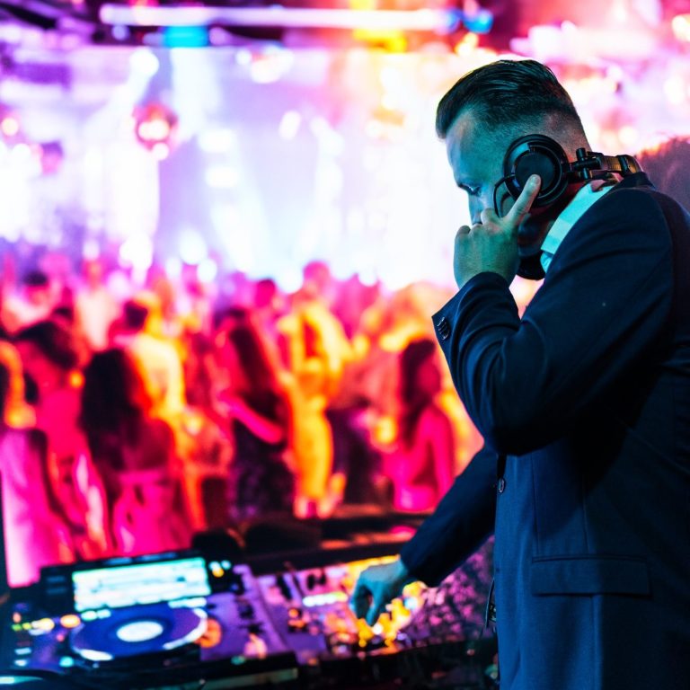 DJ Baumi am auflegen mit Tanzenden Menschen im Hintergrund